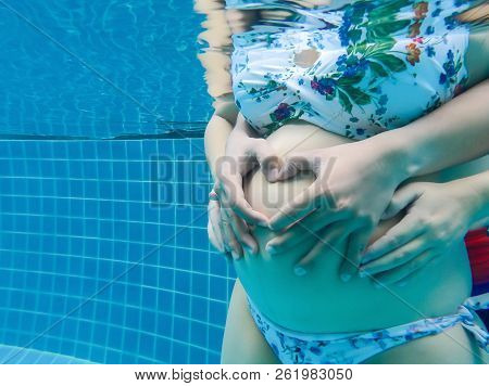 Asian Pregnant Woman With Big Belly. Relax With Husband In Swimming Pool