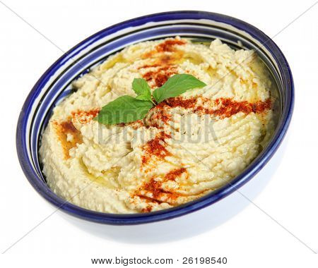 鹰嘴豆泥鹰嘴豆腥与辣椒粉和与典型的突尼斯作陶碗里的罗勒