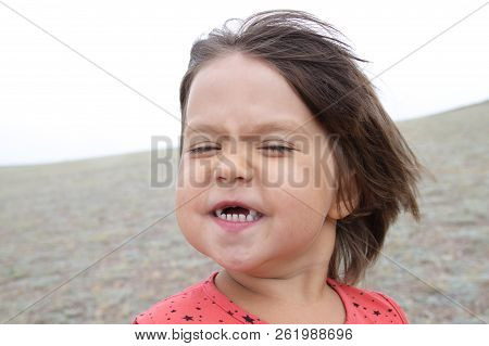 Happy Funny Girl With Expression Portrait. Wind Is Blowing. Smiling Without Teeth Little Child. Havi