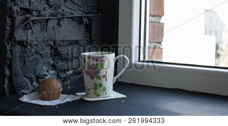 A Cup With Tea And Cupcake Near The Window