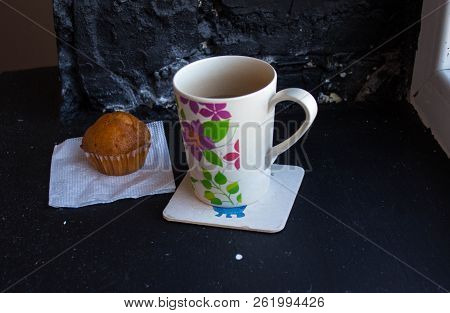 A Cup With Tea And Cupcake Near The Window