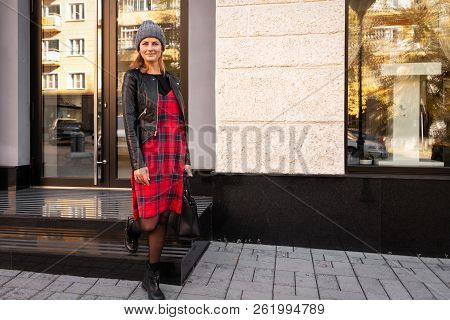Young Female Student In Warm Autumn Clothes Coming Out Of The House With A Backpack With Books  Arou
