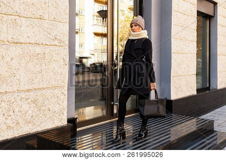 Young Female Student In Warm Autumn Clothes Coming Out Of The House With A Backpack With Books  Arou