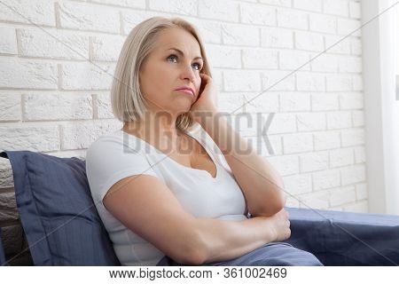 Sad Woman Sitting On The Bed At The Morning. Depressed Menopause.