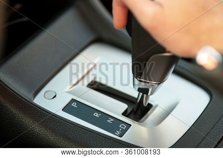 Close Up Of Woman Driver Holding Her Hand On Automatic Gear Shift Stick Driving As Car.