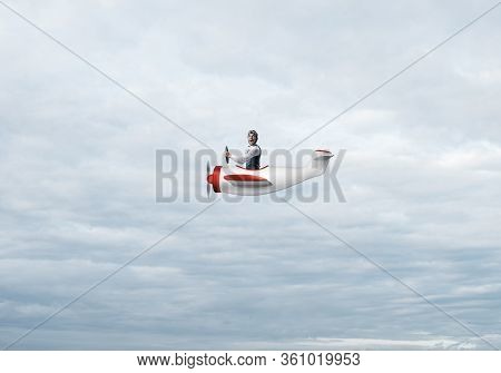 Happy Pilot Driving Small Propeller Plane On Background Of Blue Sky With Clouds. Traveling Around Th