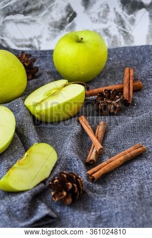 Green Golden Apples Or Granny Smith With Cinnamon Sticks Pine Fir Cones On Kitchen Towel, Preparing 