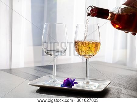 Pouring Of Rose Wine From Provence In Two Glasses In Spring Sunny Day