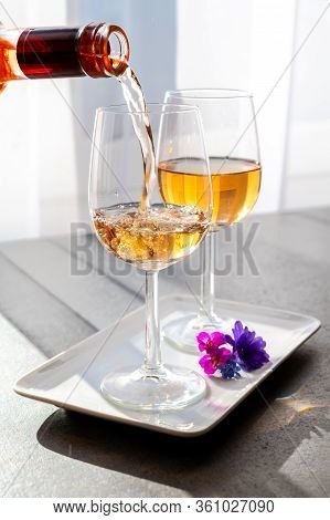 Pouring Of Rose Wine From Provence In Two Glasses In Spring Sunny Day