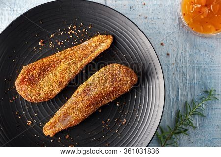 Seasoned Chicken With Hot Sauce And A Sprig Of Rosemary