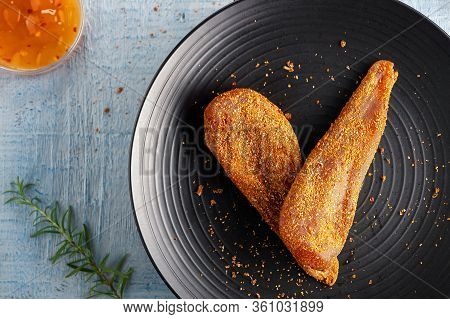Seasoned Chicken With Hot Sauce And A Sprig Of Rosemary