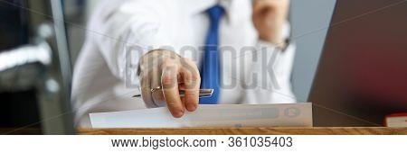 Close-up Of Persons Hand Taking Paper And Talking On Smartphone. Businessman In Presentable Suit Wea