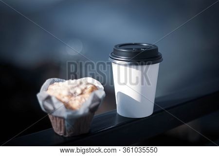 Coffee In A Disposable White Glass With A Black Lid And A Delicious Cupcake.