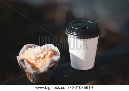 Coffee In A Disposable White Glass With A Black Lid And A Delicious Cupcake.