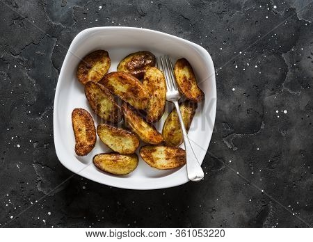 Roasted New Potatoes In Baking Dish On A Dark Background, Top View. Delicious Snack, Tapas