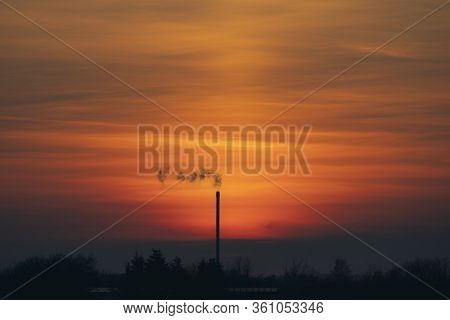 Smoke From A Chimey In A Beautiful Sunset With Industrial Silhouettes