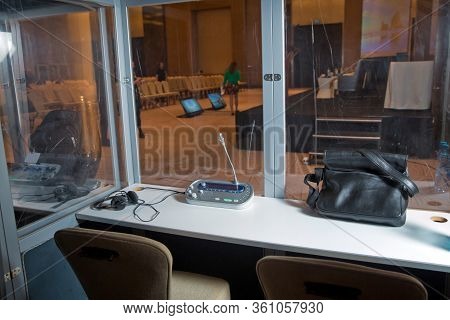 Soft Focus Of Wireless Conference Microphones And Notebook In A Meeting Room. Translators Cubicle . 