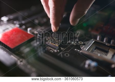 Focus At Ssd Slot, Type M.2 With Support For Nvme, On Computer Motherboard. Technician Is Installing