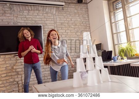 Business People Having Fun At The Office, Playing Office Games While On A Break, Knocking Down A Pyr