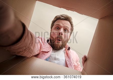 Satisfied, Surprised Man Holds Out His Hand, Trying To Get A Gift Or Parcel From An Unpacked Box. Un
