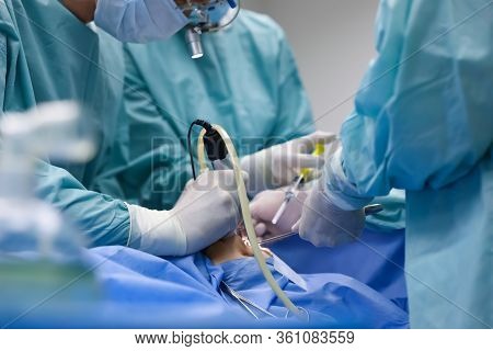 Team Of Professional Surgeons Performing Operation In Clinic