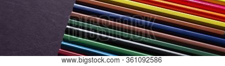 School Supplies On Dark Background. Back To School Background. Notepad And Stack Of Colorful Pencils