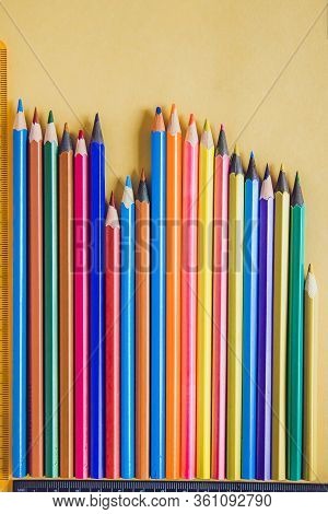 School Supplies On Yellow. Bright Back To School Background. Notepad And Stack Of Colorful Pencils. 