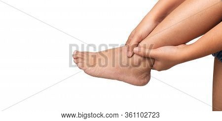 Woman Sitting With Ankle Pain Using Two Hands Holding Leg And Massaging Painful Her On White Backgro