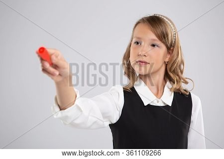 Girl Schoolgirl Writes On The Board With Red Chalk.