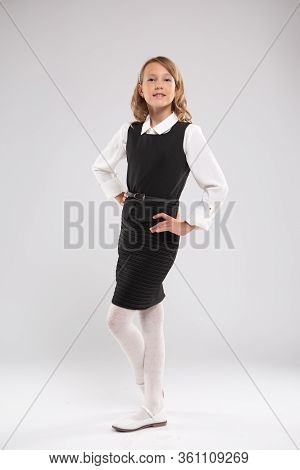 girl schoolgirl writes on the Board with red chalk.