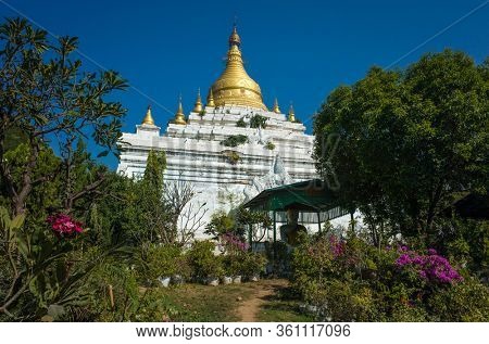Mandalay, Myanmar - January 14, 2020: White and golden pagoda at buddhist monastery Manijota Dhamma Yeiktha in Amarapura
