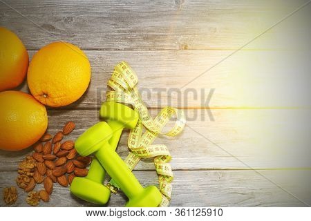 Lots Of Oranges, Dumbbells, Measuring Tape On A Wooden Textured Background. Fitness, Sports Nutritio
