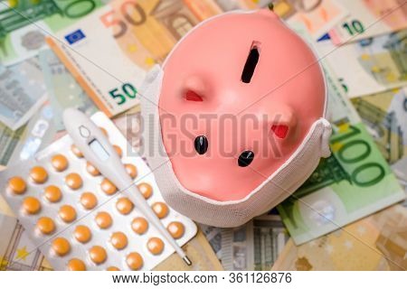 Piggy Bank In A Mask On A Background Of European Currency.the Concept Of Coronavrius Epidemic