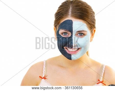 Woman With Clay Carbo Black Mask On Half Face And White Mud On Second Half. Girl Taking Care Of Oily