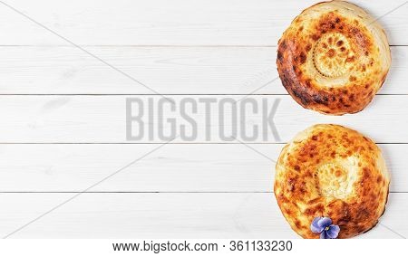 Tasty Fresh Round Tandoor Bread On A White Wooden Background. Flat Lay With Copy Space For Text Or R