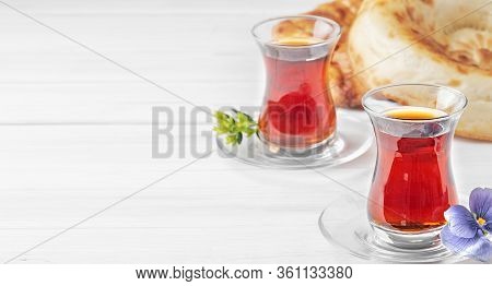 Tea In Glasses Of Armudu, Next To Two Freshly Baked Cake - Tandoor Bread, White Wooden Background. C