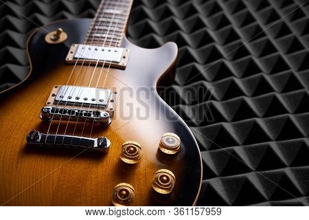 Sunburst Electric Guitar Lying On Acoustic Foam Panel Background