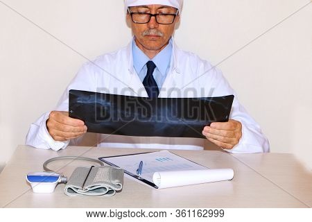 Concept - The Doctor Looks At The X-ray Of The Patient Patient Covid - 19.