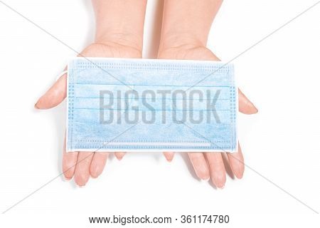 Medical Mask In Female Hands On A White Background Lay Top View. Medical Concept.