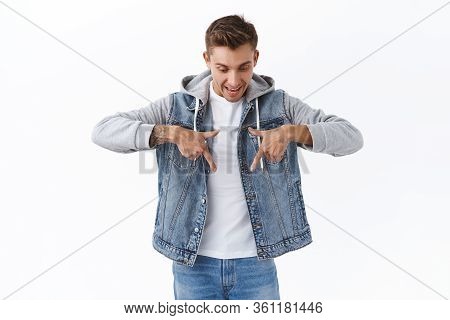 Portrait Of Astonished, Excited Happy Man Seeing Great Advertisement, Looking Down And Pointing Fing