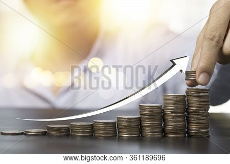 Hand Putting Coins Stacking With Rising Arrow.dividend Of Banking Deposit And Stock Investment Conce