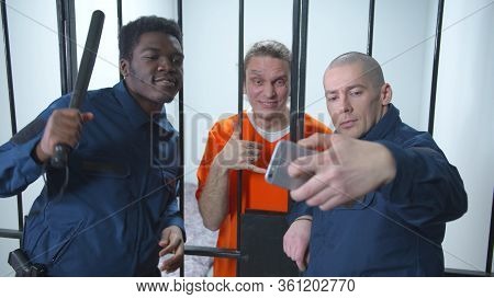 Jailers Take Selfies With Prisoners. Medium Shot
