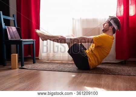 Young Man Practices Yoga In Navasana Asana . Male Yogi In Boat Pose
