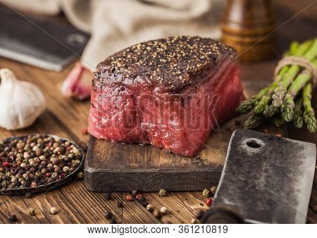 Slice Of Raw Beef Topside Joint With Salt And Pepper On Wooden Chopping Board With Meat Hatchet, Gar