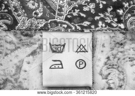 Care Clothes Label On Black And White Tetile Background Closeup