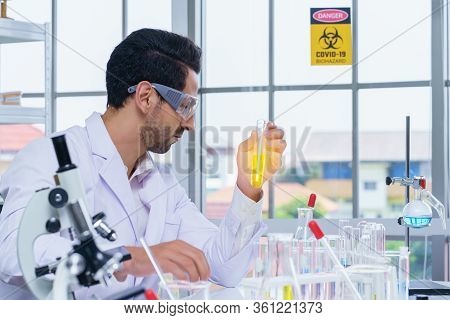 Doctor And Microbiologist With Vacuum Tubes For Samples With Covid-19 Coronavirus Chinese Infection