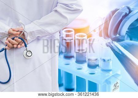 Doctor And Microbiologist With Vacuum Tubes For Samples With Covid-19 Coronavirus Chinese Infection