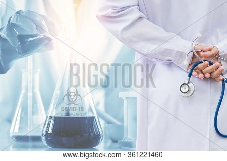 Doctor And Microbiologist With Vacuum Tubes For Samples With Covid-19 Coronavirus Chinese Infection