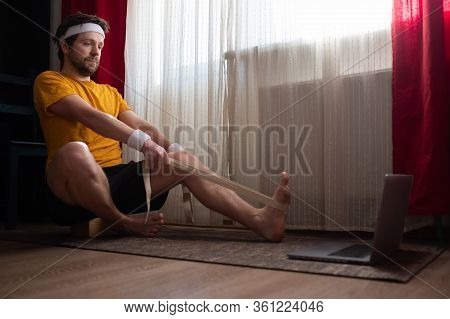 Man Sitting In Janushirshasana , Exercise For Hips And Spine At Home Using Belt