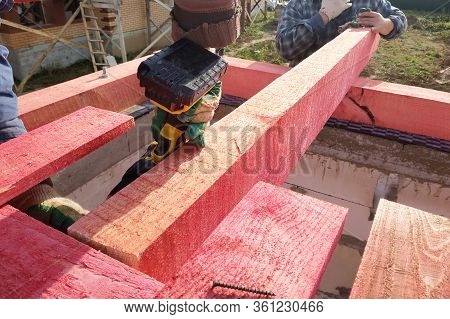 Workers Mount Wooden Beams For The Roof.